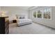 Bright main bedroom featuring plush carpet, tray ceiling and a large window for natural light at 3878 Amicus Dr, Buford, GA 30519
