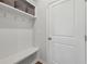 Mudroom area featuring a built-in bench with hooks and baskets for storage and a white door at 3878 Amicus Dr, Buford, GA 30519