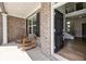 Inviting front porch featuring rocking chairs, brick accents, and a view into the foyer at 3878 Amicus Dr, Buford, GA 30519