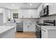 Kitchen with white cabinets, stainless steel appliances, island and stylish tile backsplash at 3351 Grand Central Dr, Snellville, GA 30078