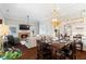 Dining room with hardwood floors, modern lighting fixture, fireplace, and open view of living room and kitchen at 4121 N Swann St, Covington, GA 30014