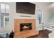Close up of fireplace with brick surround, hardwood floors, and natural lighting from nearby window at 4121 N Swann St, Covington, GA 30014