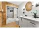 Bathroom featuring a shower over tub, wood accent wall, and modern vanity at 5785 Woodruff Rd, Chattahoochee Hills, GA 30213