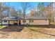 Single-story home with an attached garage and a covered patio area, set on a lush green lawn at 5785 Woodruff Rd, Chattahoochee Hills, GA 30213