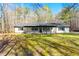 Inviting single-story home with a covered front porch, black shutters and a manicured lawn at 5785 Woodruff Rd, Chattahoochee Hills, GA 30213
