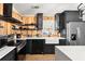 Modern kitchen featuring custom wood accent wall, black cabinets and stainless steel appliances at 5785 Woodruff Rd, Chattahoochee Hills, GA 30213