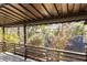 Covered outdoor deck with railing has views of the wooded yard at 1275 Calhoun Ave, Atlanta, GA 30344