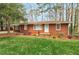 Charming brick home featuring a well-maintained lawn and mature trees at 1334 Jennie Sw Ln, Lilburn, GA 30047