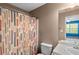 Neutral-toned bathroom featuring a shower with patterned curtain and access to an adjacent bedroom at 15 Glen Echo Dr, Covington, GA 30016