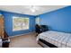 A blue painted bedroom with ceiling fan, large window, and desk area at 15 Glen Echo Dr, Covington, GA 30016
