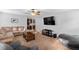 Cozy living room featuring a plush sectional sofa, ceiling fan, and large television at 15 Glen Echo Dr, Covington, GA 30016