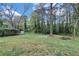 Lush backyard with mature trees, a fire pit, and private shed at 3632 Glen Mora Drive, Decatur, GA 30032