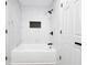 Bright white bathroom features a soaking tub with modern black fixtures, and marble-style tile at 3632 Glen Mora Drive, Decatur, GA 30032