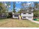 Split-level home with a yellow door, attached garage, and landscaping at 3632 Glen Mora Drive, Decatur, GA 30032