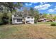 View of the split-level home surrounded by mature trees and a lush green lawn at 3632 Glen Mora Drive, Decatur, GA 30032