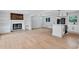 Open-concept living space and kitchen featuring a fireplace, hardwood floors and modern appliances at 3632 Glen Mora Drive, Decatur, GA 30032