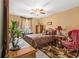 Bedroom featuring a ceiling fan, window with curtains, bed, and sitting area with a red armchair at 2728 Keystone Gates Ct, Lithonia, GA 30058