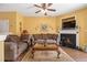 Cozy living room with a fireplace, comfortable seating, and a ceiling fan for added comfort at 2728 Keystone Gates Ct, Lithonia, GA 30058