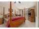 Main bedroom with four poster bed, ceiling fan, and corner entertainment center at 2728 Keystone Gates Ct, Lithonia, GA 30058