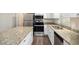Modern kitchen featuring stainless steel appliances, granite countertops, and white cabinets at 6510 Hazel St, Lithia Springs, GA 30122