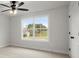 Bright bedroom with a ceiling fan, plush carpet and natural light through the large window at 5010 Hyde Way, Cumming, GA 30040