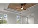 Bedroom featuring tray ceilings with fan, large windows, and neutral color palette at 5010 Hyde Way, Cumming, GA 30040