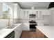 Well-lit kitchen featuring white cabinets, stainless steel appliances, granite countertops, and a stylish gold faucet at 5010 Hyde Way, Cumming, GA 30040
