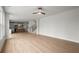Spacious open floor plan with hardwood floors, a ceiling fan, and a view of the kitchen at 5010 Hyde Way, Cumming, GA 30040