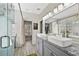 Elegant bathroom with a double vanity, walk-in shower, and tub; complemented by wood-look tile floors at 1151 Adah Ln, Lawrenceville, GA 30043
