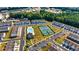 Stunning aerial view of a community featuring a swimming pool and tennis courts surrounded by lush green trees at 228 Auburn Valley Way, Auburn, GA 30011