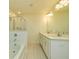 Bright bathroom featuring a double vanity, large mirror and tiled shower and tub at 228 Auburn Valley Way, Auburn, GA 30011