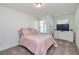 Cozy bedroom with plush pink bedding, carpet, and bright natural light from the windows at 228 Auburn Valley Way, Auburn, GA 30011