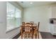 Bright dining area with a wooden table set next to a window with blinds at 228 Auburn Valley Way, Auburn, GA 30011