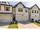 Stylish townhomes feature painted white brick facades, black trim, and private one-car garages at 228 Auburn Valley Way, Auburn, GA 30011
