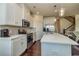 Open kitchen with white cabinets, quartz counters, stainless appliances, and a view of the staircase at 228 Auburn Valley Way, Auburn, GA 30011