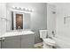 This bathroom has a grey vanity, a white toilet, a white shower/tub, and a mirror with lights at 386 Northdale Ct, Lawrenceville, GA 30046