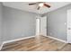This bedroom has wood floors, neutral colored walls, a ceiling fan, and two doors at 386 Northdale Ct, Lawrenceville, GA 30046