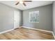 This bedroom has a ceiling fan, wood floors, a window with blinds, a door, and light grey walls at 386 Northdale Ct, Lawrenceville, GA 30046