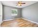 This bedroom features a ceiling fan, wood floors, a window with blinds, and light grey walls at 386 Northdale Ct, Lawrenceville, GA 30046