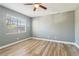 This bedroom has a ceiling fan, a window with blinds, wood floors, and neutral colored walls at 386 Northdale Ct, Lawrenceville, GA 30046