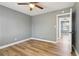 This bedroom has wood floors, neutral colored walls, a ceiling fan, and a doorway at 386 Northdale Ct, Lawrenceville, GA 30046