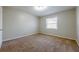 A well-lit bedroom offers neutral walls, soft brown carpet, and a bright window for a cozy retreat at 1010 Scott Blvd # D8, Decatur, GA 30030