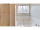 Relaxing bathtub with natural light from a window and a separate shower stall at 1924 Sidneys Cv, Lawrenceville, GA 30043