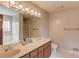 Bright bathroom featuring double sinks, large mirror, and separate bathtub at 1924 Sidneys Cv, Lawrenceville, GA 30043