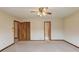 Bedroom featuring a ceiling fan, neutral carpet, and doorways to an adjacent room and closet at 1924 Sidneys Cv, Lawrenceville, GA 30043