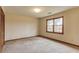Bedroom with neutral carpeting, wood trim and a large window at 1924 Sidneys Cv, Lawrenceville, GA 30043