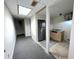 View of hall to small kitchenette area with stainless steel refrigerator, countertop and cabinets at 1924 Sidneys Cv, Lawrenceville, GA 30043