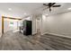 Bright living room with gray wood flooring, ceiling fan, wood beam and an open layout to the kitchen at 2968 Cleburne Pkwy, Powder Springs, GA 30127