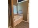 Bathroom featuring a bright white bathtub, stylish tile accents, and durable wood-look flooring for a relaxing retreat at 8827 Lake Rd, Union City, GA 30291