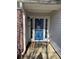 Inviting front entryway with blue door, sidelights, brick accents, and neutral siding for a welcoming curb appeal at 8827 Lake Rd, Union City, GA 30291